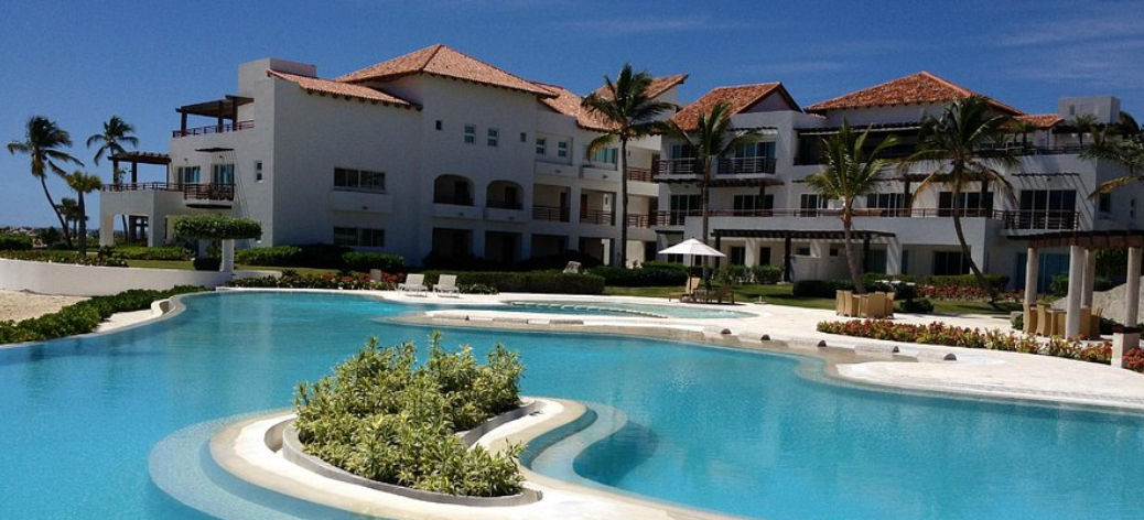 Oceanfront infinity pool and luxury suite buildings at Punta Palmera Cap Cana by Essenza Retreats