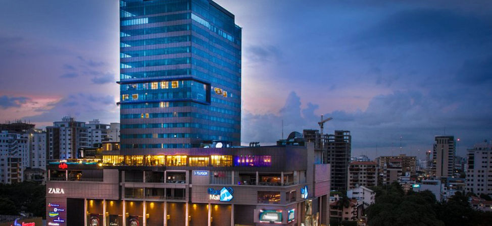 Vista exterior del JW Marriott Hotel Santo Domingo y Blue Mall iluminados al atardecer