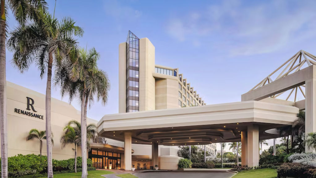 Renaissance Santo Domingo Jaragua Hotel & Casino main entrance and exterior facade featuring palm trees and a clear blue sky.