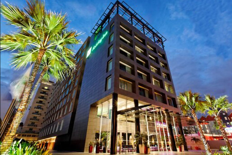 Fachada exterior del hotel Holiday Inn Santo Domingo iluminada al atardecer