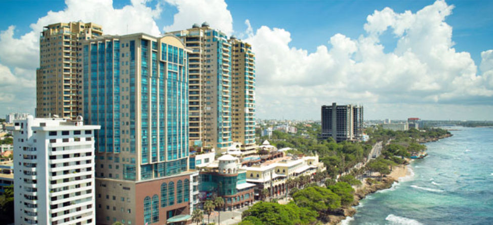 Vista panorámica del hotel Catalonia Santo Domingo y edificios de gran altura a lo largo del Malecón, frente a la costa del Mar Caribe bajo un cielo nublado.