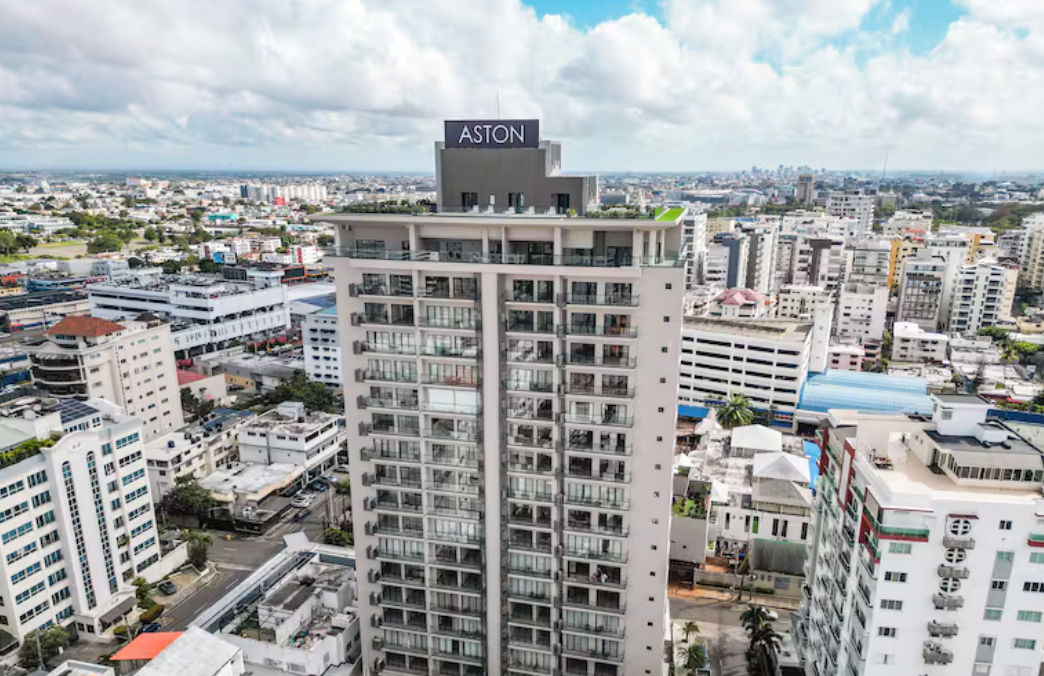 Aerial view of the Aston Rubi City Suites residential tower surrounded by the city urban landscape