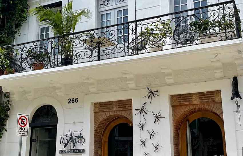 Fachada colonial del Mosquito Boutique Hotel Zona Colonial con su distintivo letrero y decoraciones de mosquitos en la entrada.