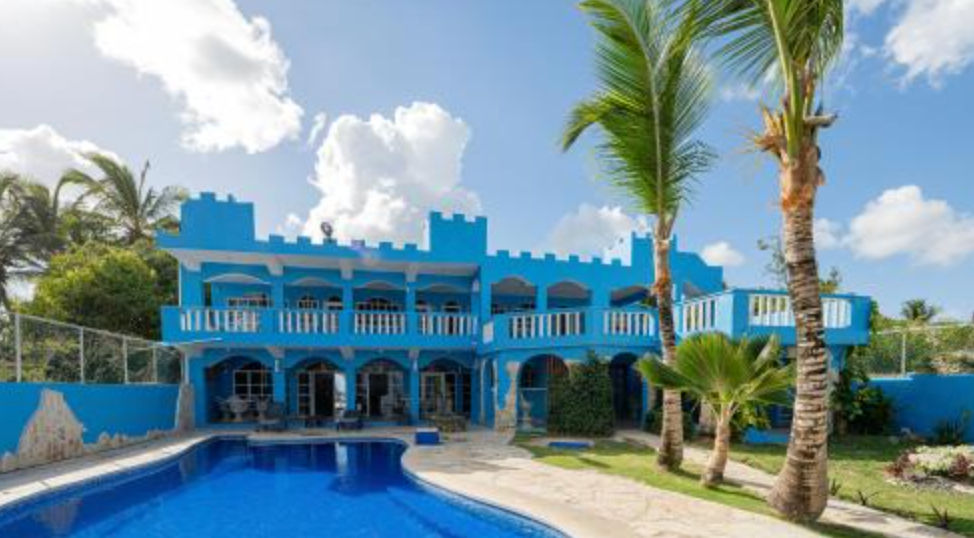 Outdoor swimming pool and castle-style blue facade of Hotel Boca de Yuma in the Dominican Republic