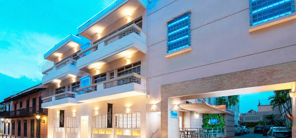 Fachada iluminada del hotel boutique Hodelpa Caribe Colonial por la tarde en la Zona Colonial de Santo Domingo.