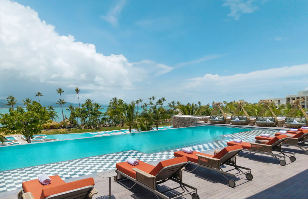Spectacular swimming pool at a Punta Cana hotel featuring comfortable Balinese beds and in-water lounge chairs under the Caribbean sun