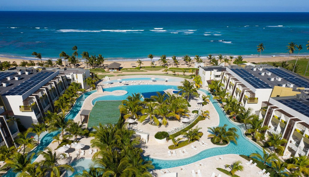 Facilities of a luxury all-inclusive resort in Punta Cana featuring palm trees and lounge areas next to the pool