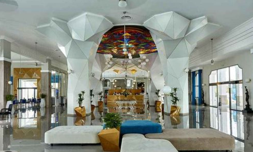Luxury hotel suite at Riu Palace featuring a spacious bed, elegant modern interior design, integrated living area, and private balcony