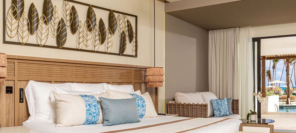 Elegant and modern room at Secrets Tides Punta Cana resort featuring luxury finishes, a seating area, and views of the outdoor tropical landscape