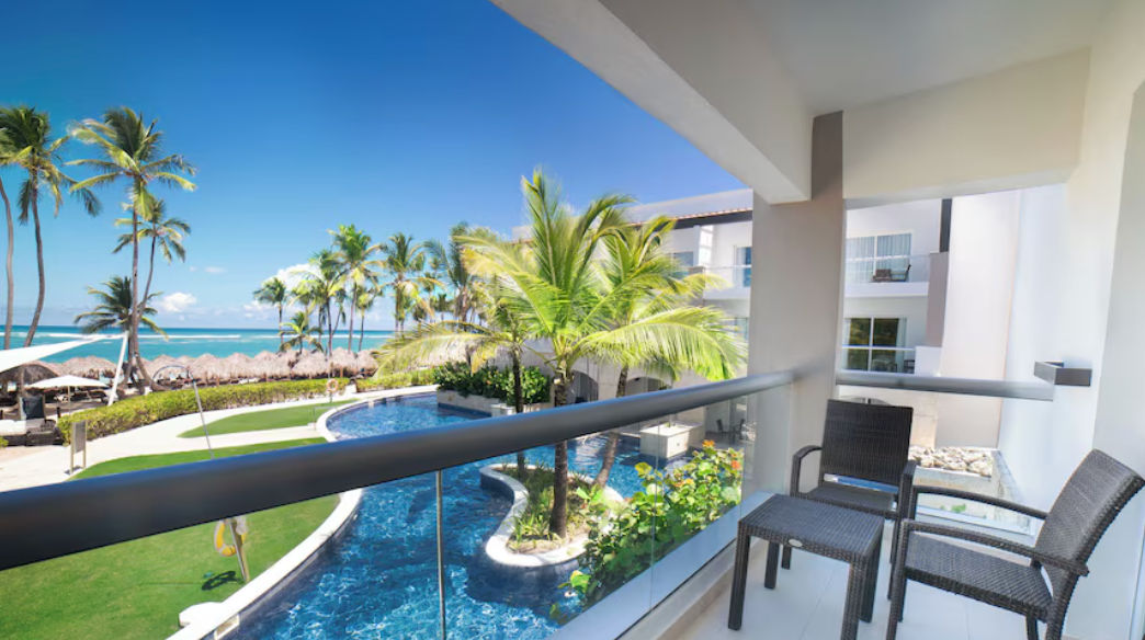View from the exterior balcony of a room at Royalton hotel showing private terraces, tropical gardens, and direct swim-up pool access