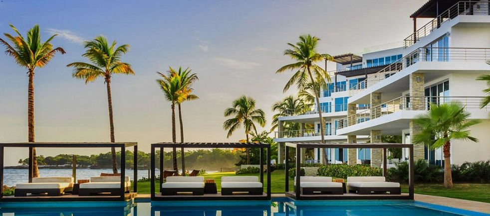Vista de The Ocean Club a Luxury Collection Resort Costa Norte con piscina iluminada al anochecer - Modern luxury beachfront resort in Dominican Republic
