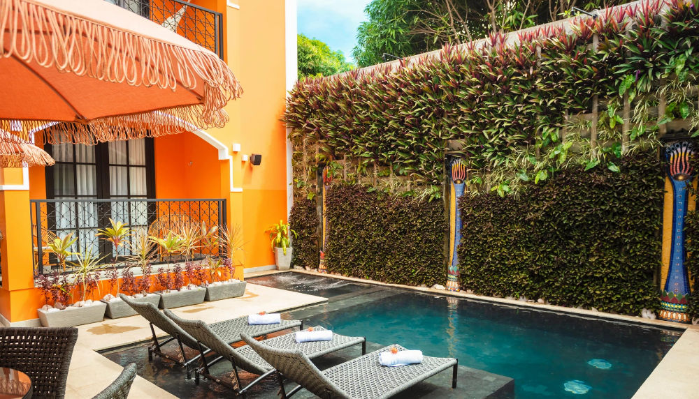 Fachada iluminada del Exotica Boutique Hotel en Punta Cana con arquitectura de estilo árabe y mosaicos coloridos