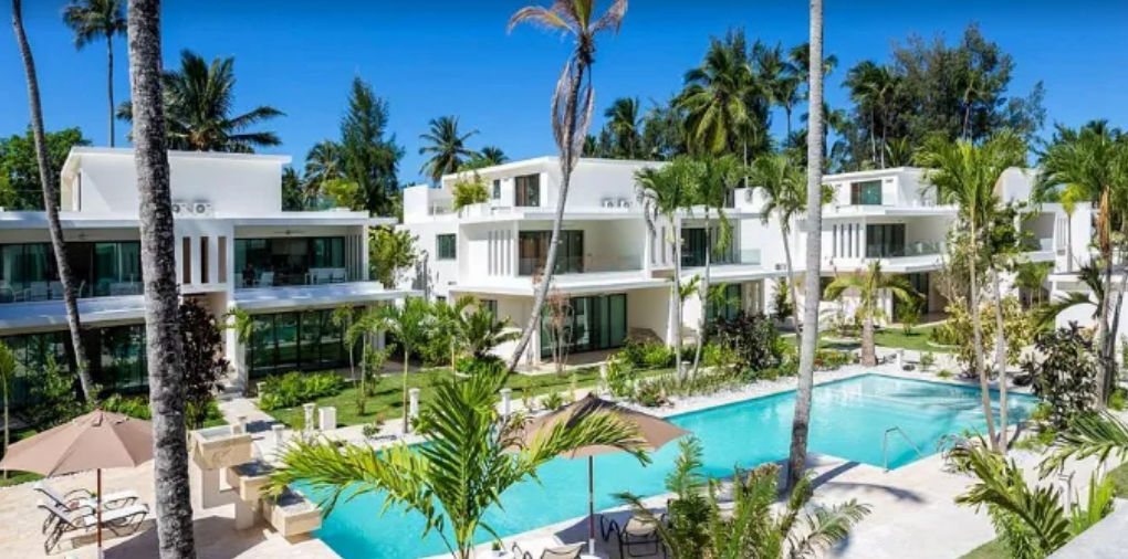 Modernas villas blancas de Ultima Retiro Cabarete con piscina tropical y palmeras