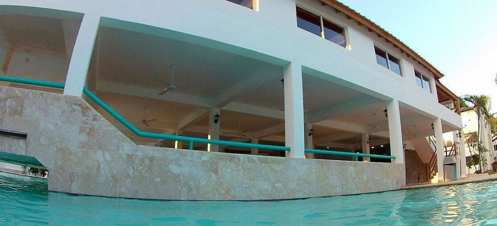 Outdoor swimming pool and covered bar area at Ahnvee Resort and Sports in Sosua