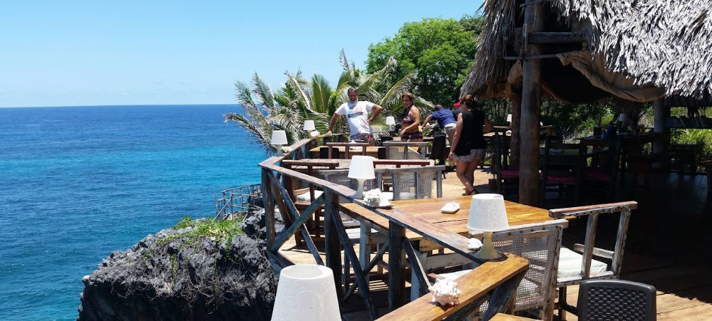 Rustic orange bungalow with thatched roof in a lush tropical garden - El Cabito, Las Galeras