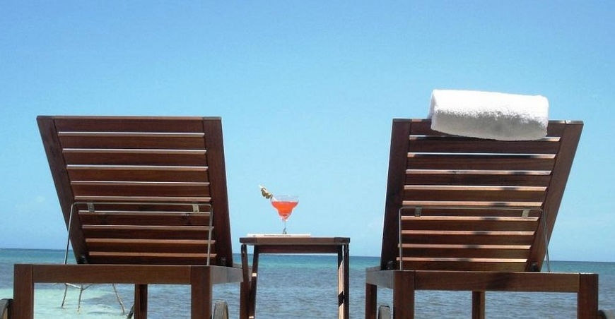 Instalaciones del Cayo Arena Beach Eco Hotel en Punta Rucia, República Dominicana, con su arquitectura moderna, cabaña de techo de paja y turbina eólica ecológica