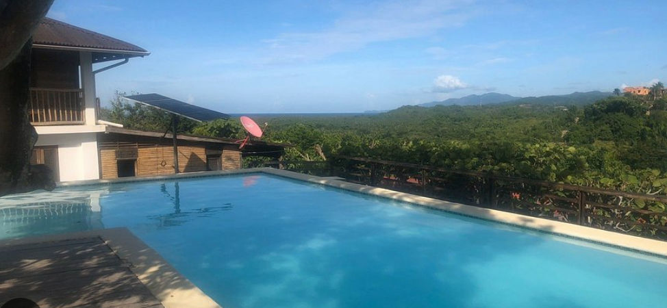 Eco-friendly villas with red roofs at Clave Verde Ecolodge surrounded by lush tropical vegetation in Las Terrenas