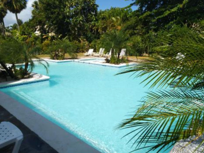 Exterior facade of Hotel Coco Plaza in Las Terrenas Dominican Republic with Caribbean architecture and palm trees