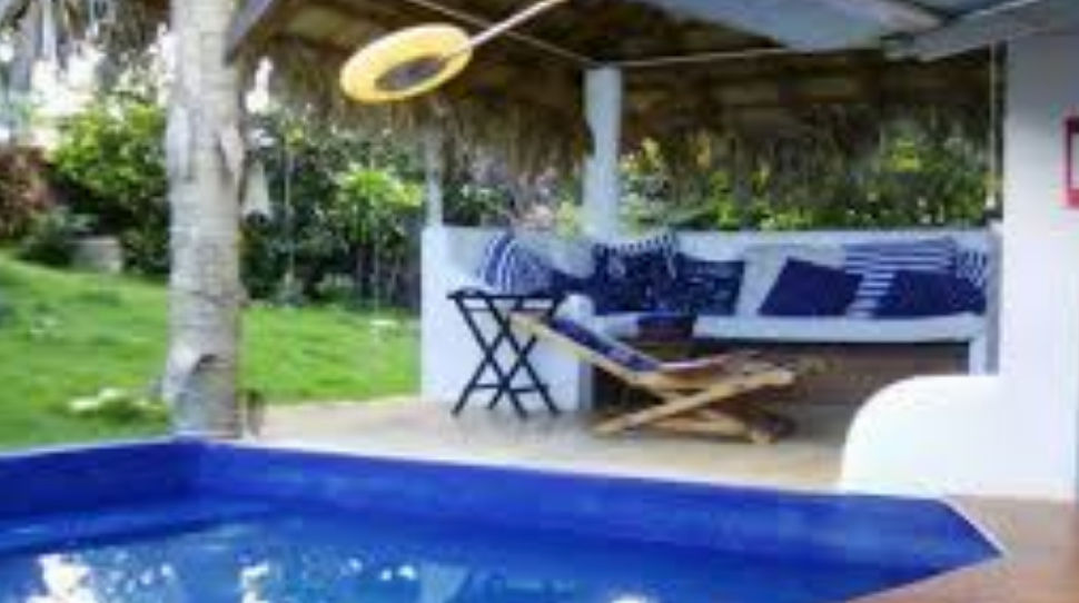 Vista panorámica de cabañas y bungalows de estilo caribeño rodeados de vegetación tropical bajo un cielo despejado en República Dominicana