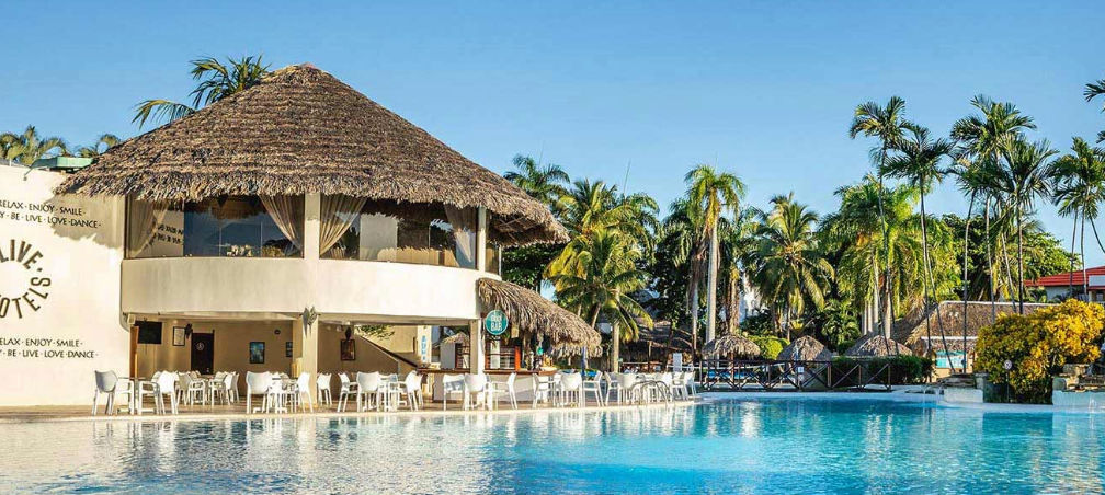 Aerial view of the main swimming pool at Be Live Collection Marien resort with Isabel de Torres mountain in the background in Puerto Plata