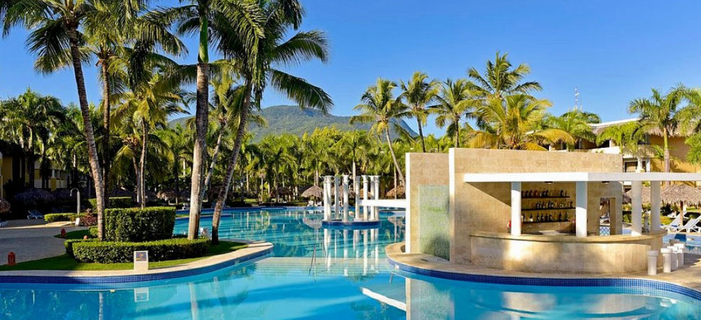 Vista aérea de un resort todo incluido frente al mar en República Dominicana con playas de agua turquesa y piscinas tropicales