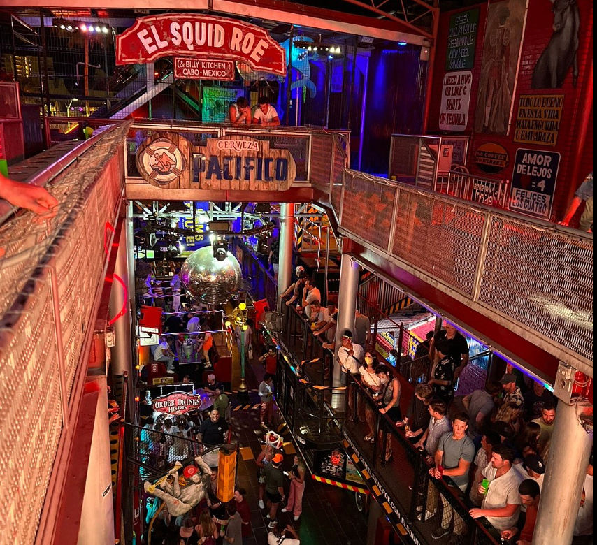 Vista interior de El Squid Roe: Guía de transporte aeropuerto Cancún Interior del animado bar El Squid Roe en Cabo San Lucas, destino popular para turistas que buscan transporte desde el aeropuerto de Cancún a su hotel