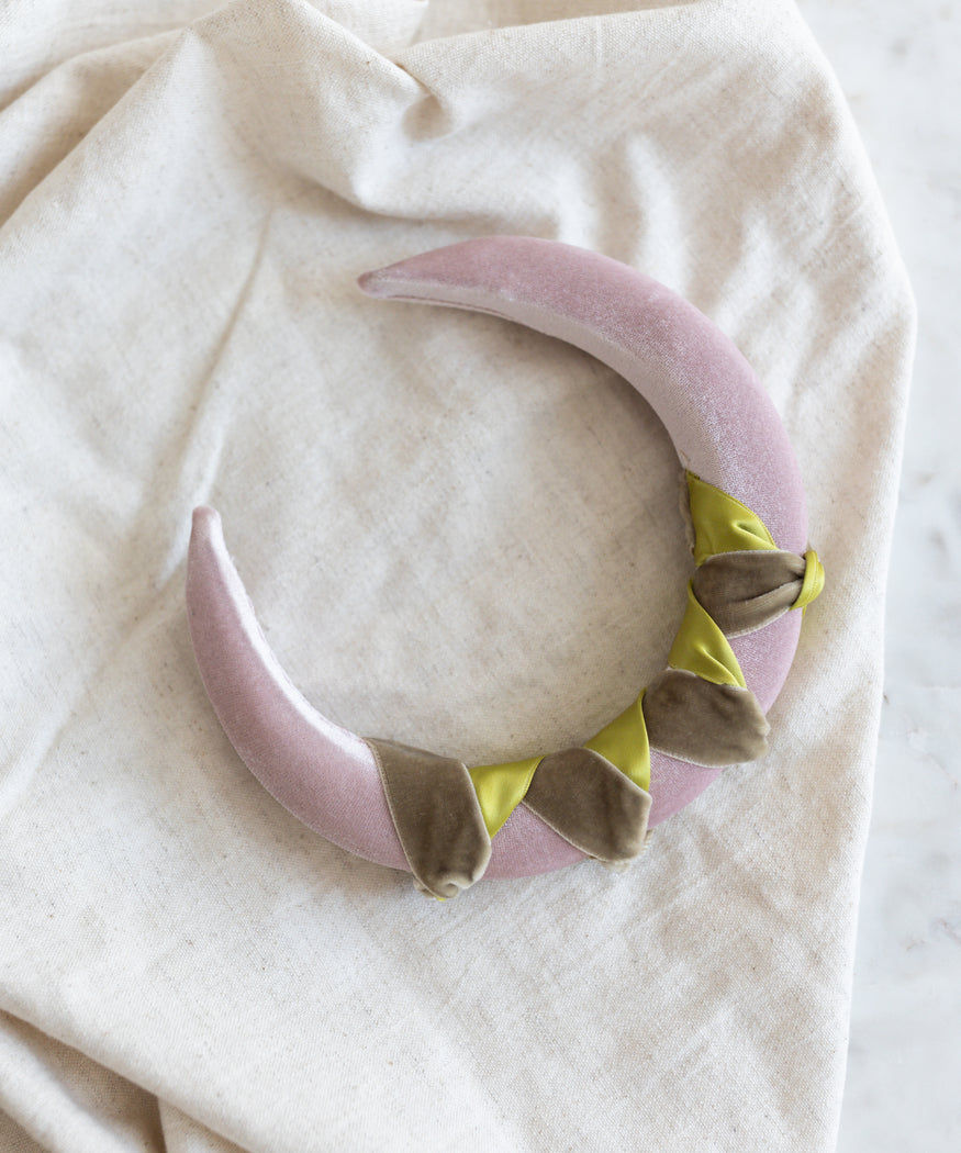 A WALD Berlin Headband Knot Rose necklace on a white cloth.