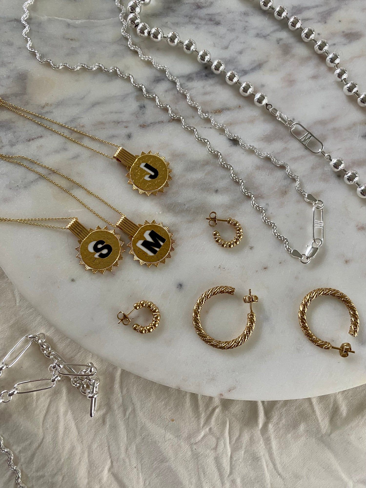 A collection of WALD Berlin jewelry on a marble table in Germany's capital city, Berlin.