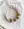 A WALD Berlin Headband Knot Rose necklace on a white cloth.