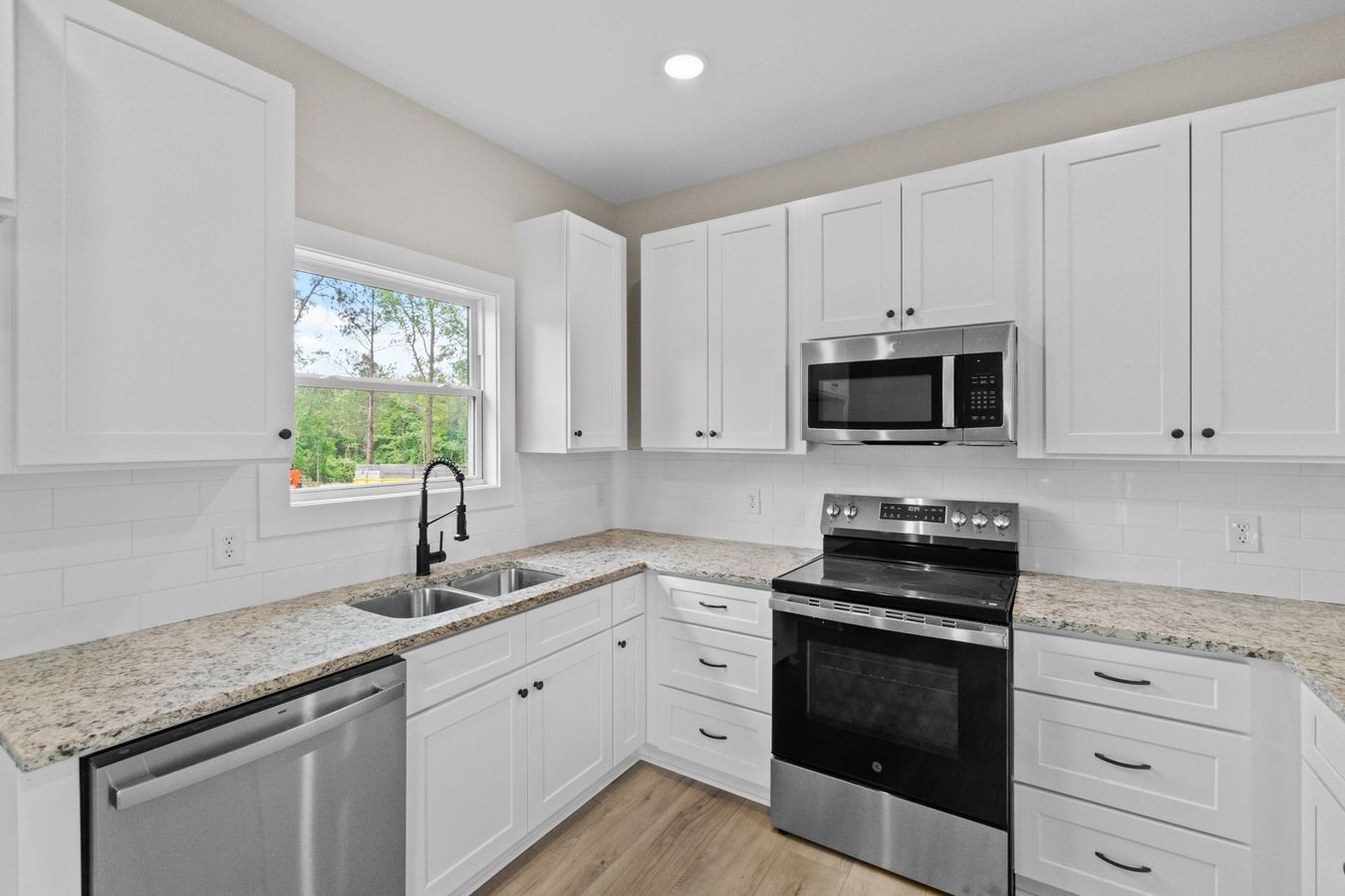 Kitchen view with granite counters and window over sink