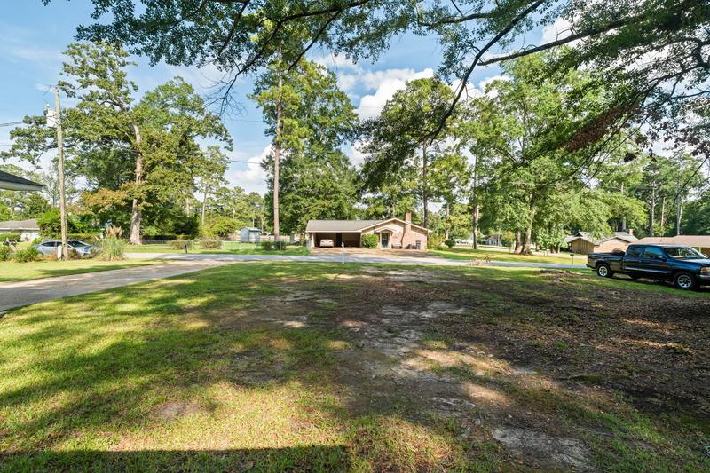 Front lawn and mature trees with a view toward the street