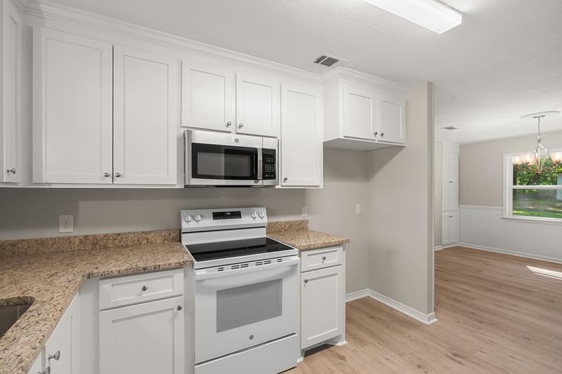 Kitchen range and microwave surrounded by white cabinetry