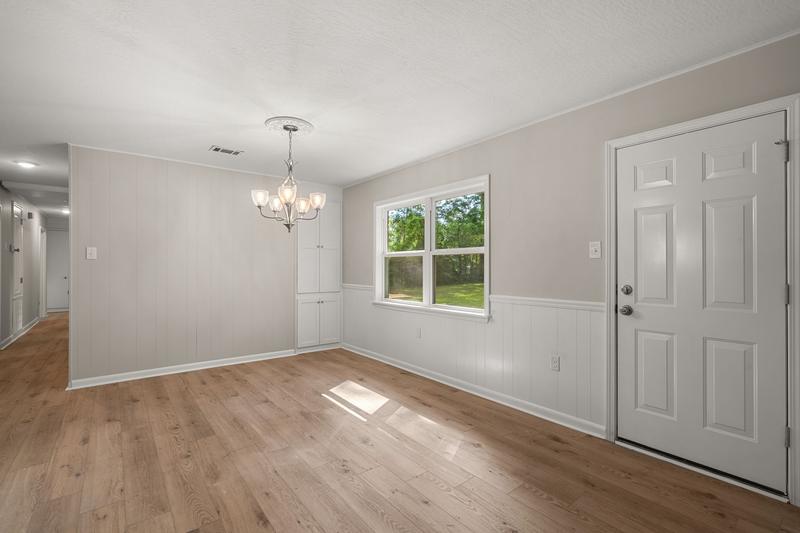 Dining area with a chandelier, plank flooring, and adjacent doorways