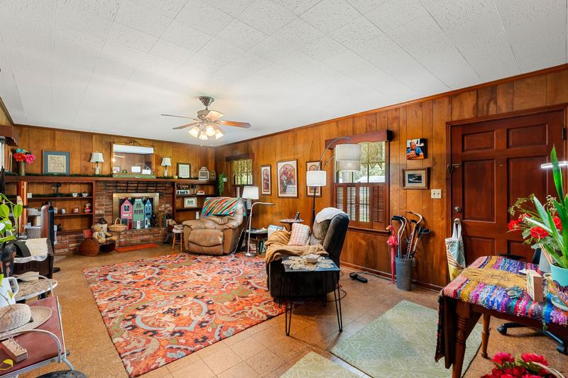 Paneled family room with decorative brick fireplace and built-in shelving