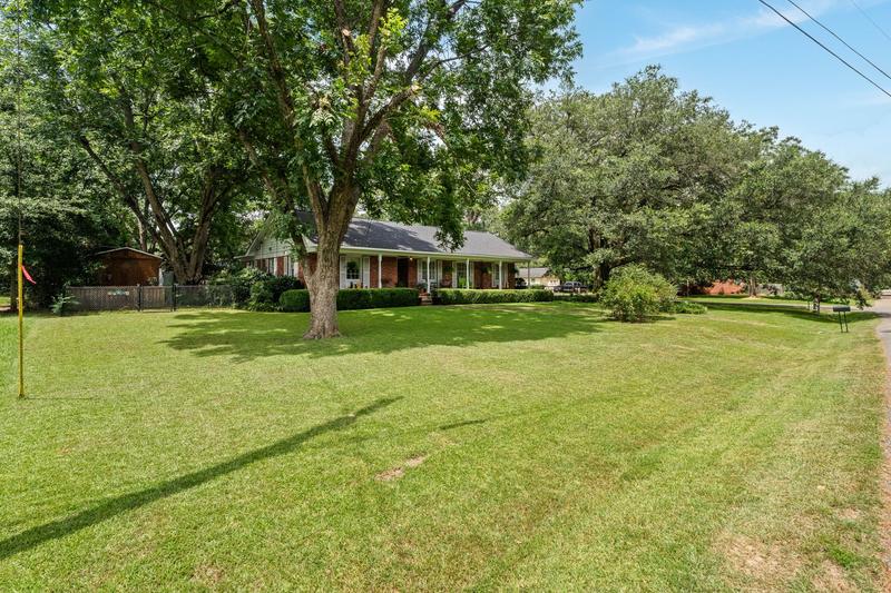Front yard shaded by mature trees at 703 W 29th St, Laurel MS