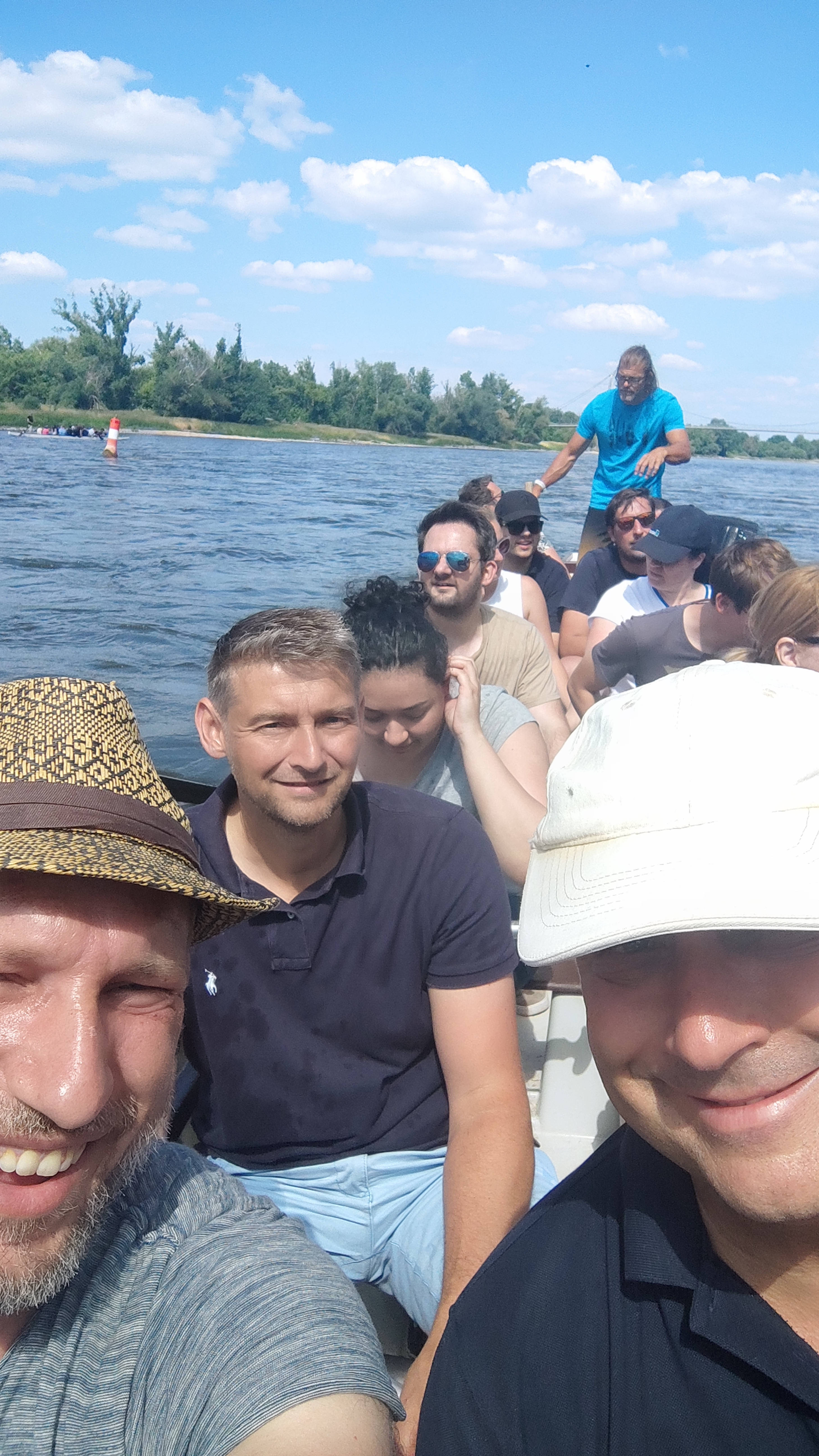 Gruppe von Personen bei einer Bootsfahrt auf einem Fluss an einem sonnigen Tag.