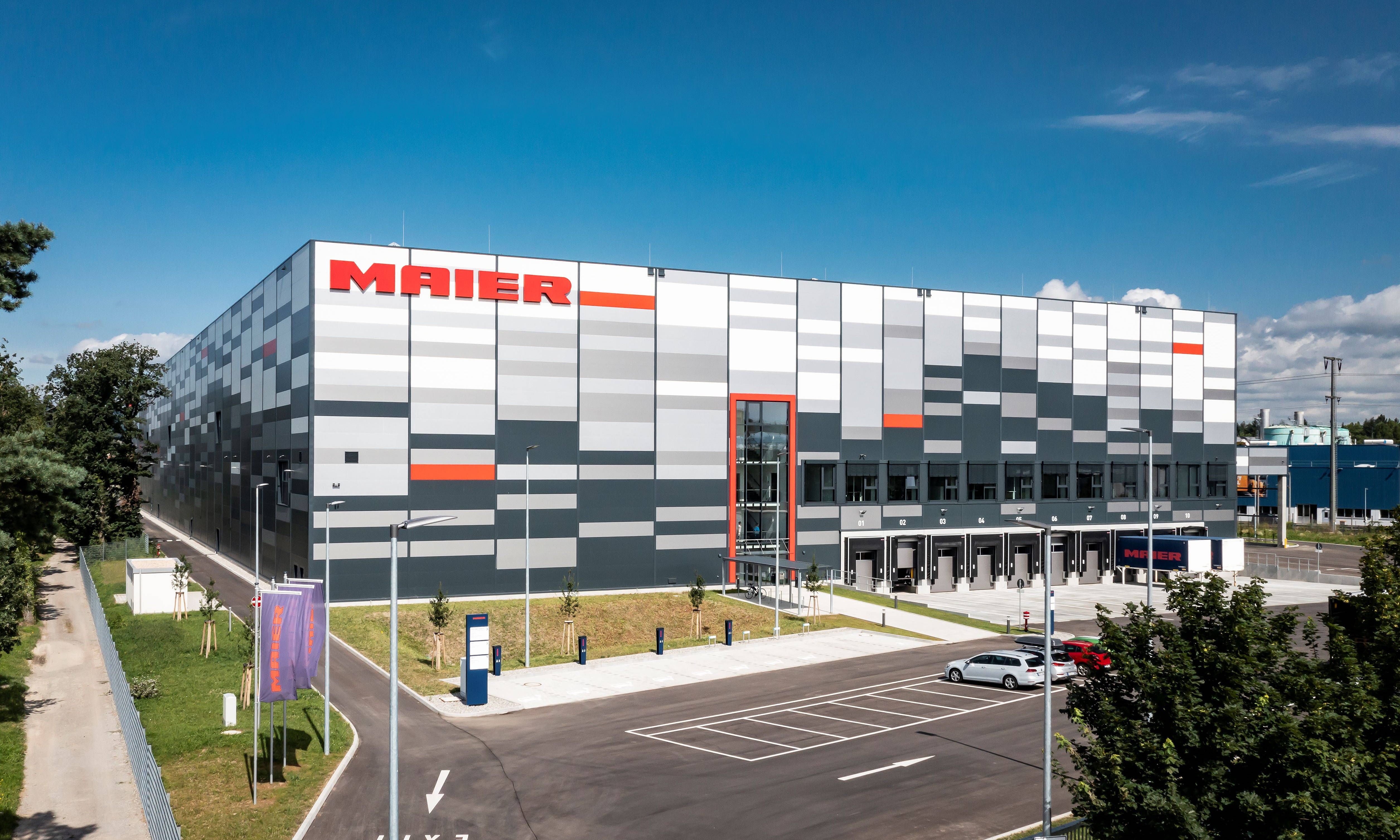 Front view of a multi-story shipping hall with parking areas.