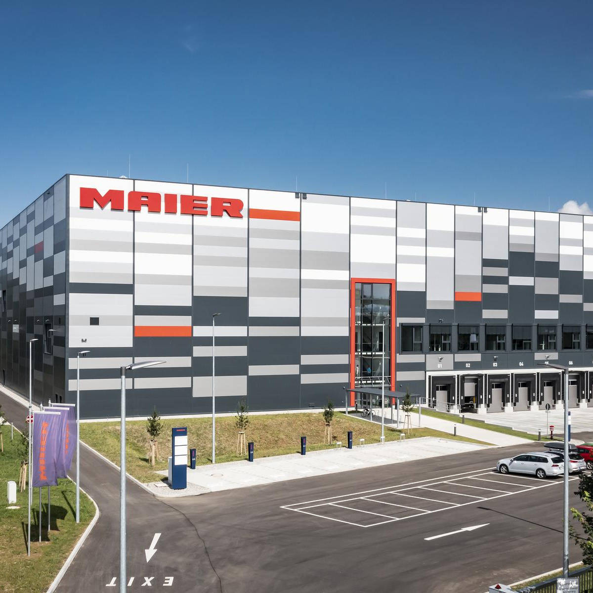 Front view of a multi-story shipping hall with parking areas.