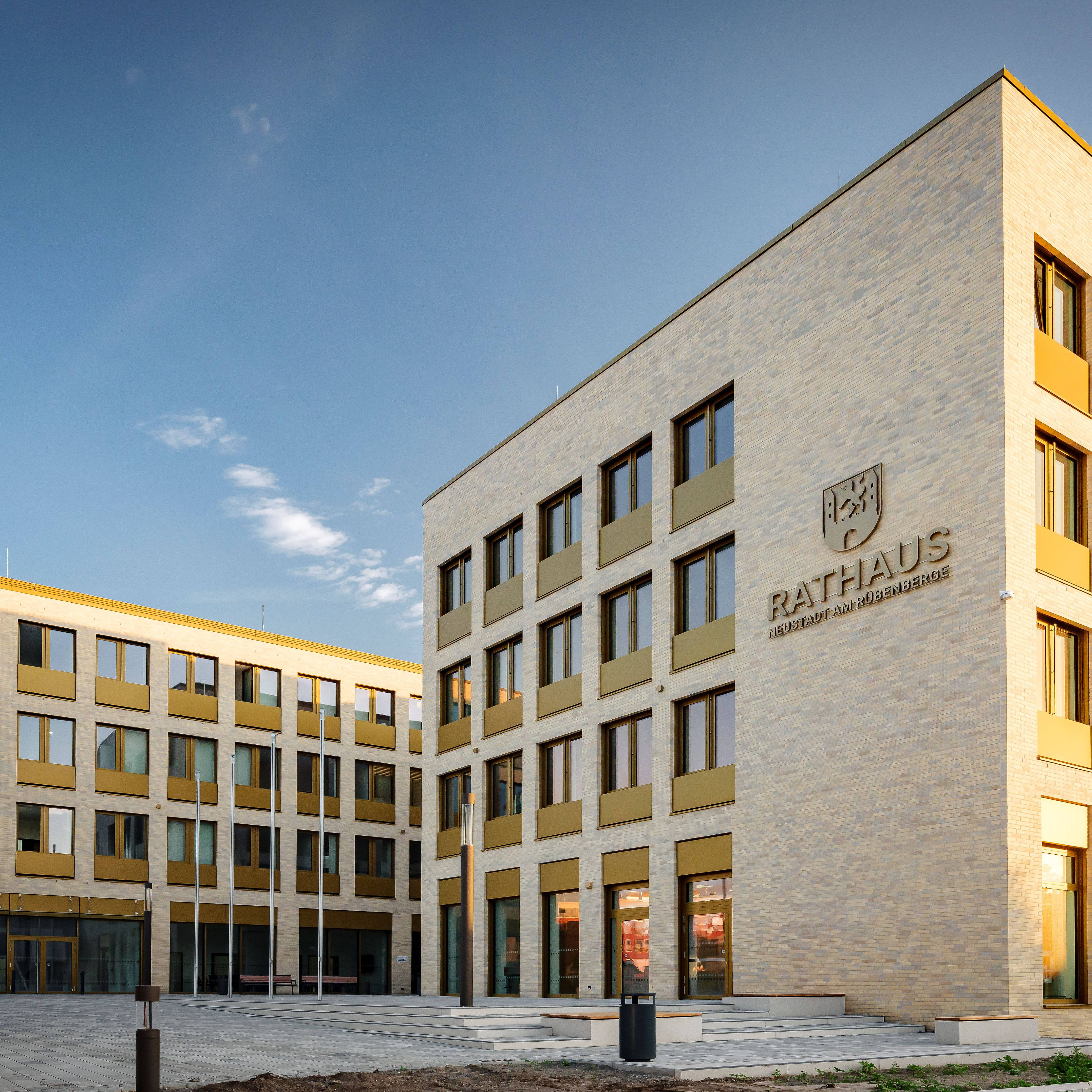 Modernes Rathausgebäude bei Sonnenuntergang, rechteckige Architektur mit großen Fenstern und heller Fassade.