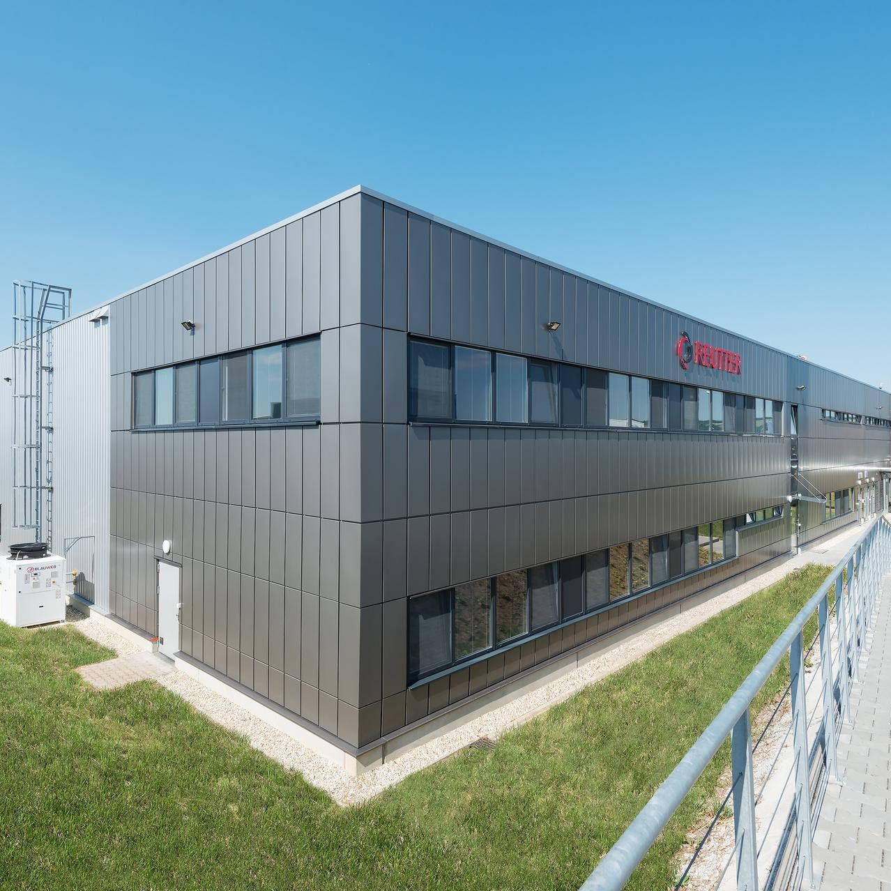 Außenansicht einer Produktionshalle mit einer grauen Fassade