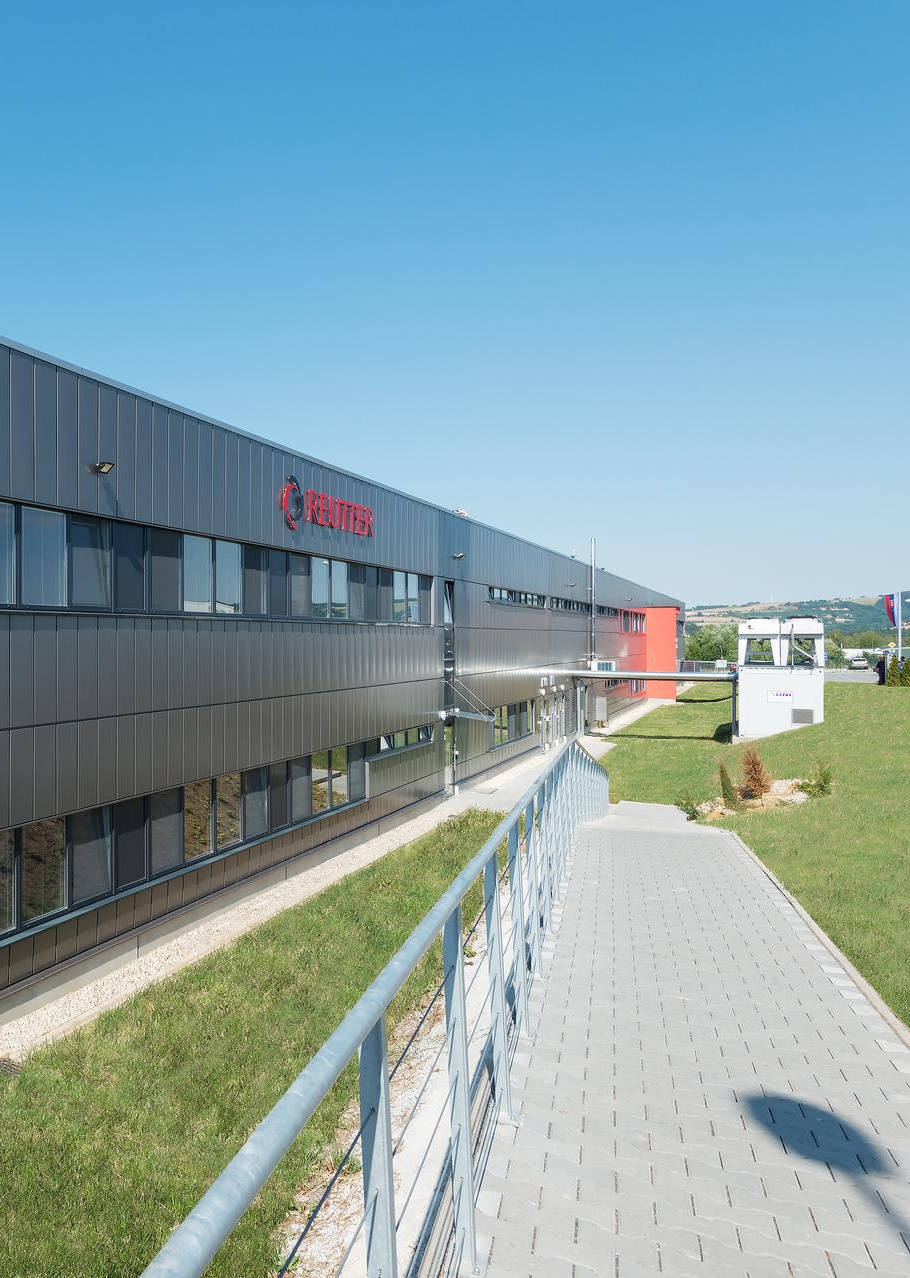 [Translate to English:] Außenansicht einer Produktionshalle mit einer grauen Fassade
