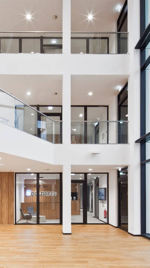 Moderne Eingangshalle mit Glasfassaden, Holzverkleidung und digitaler Anzeigetafel, Bürogebäude-Innenansicht.