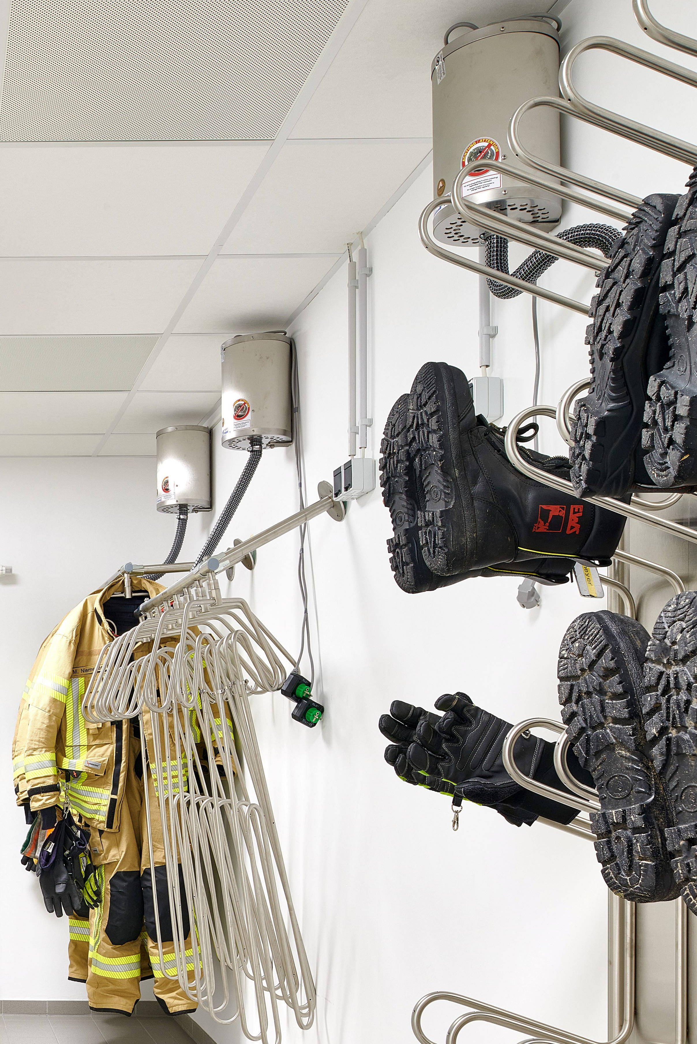 Ein Flur mit einer Garderobe für die Feuerwehrausrüstung.