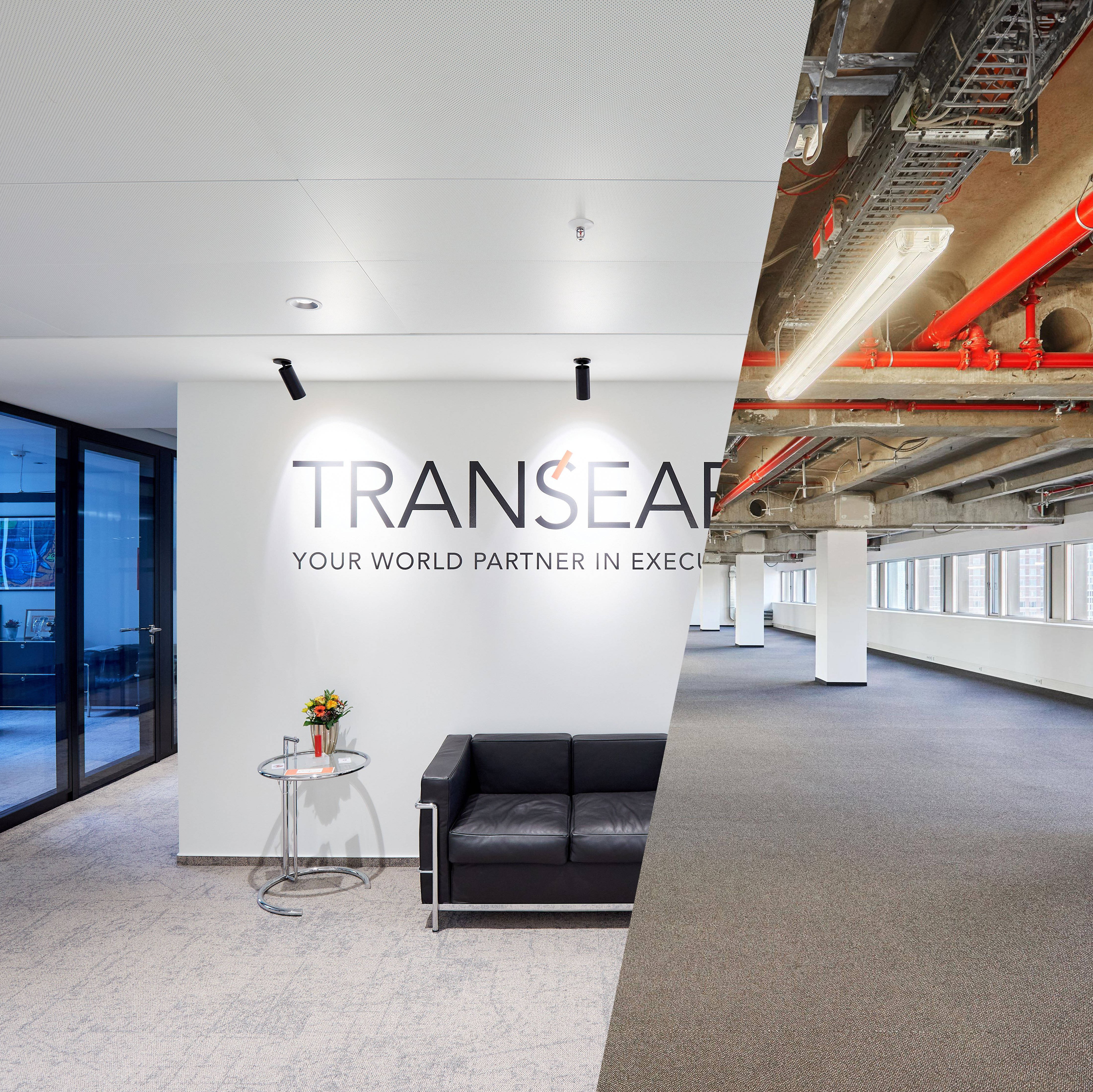 Modern office entrance area with black sofa and round table on the left, adjacent unfinished office space with visible pipes on the right.
