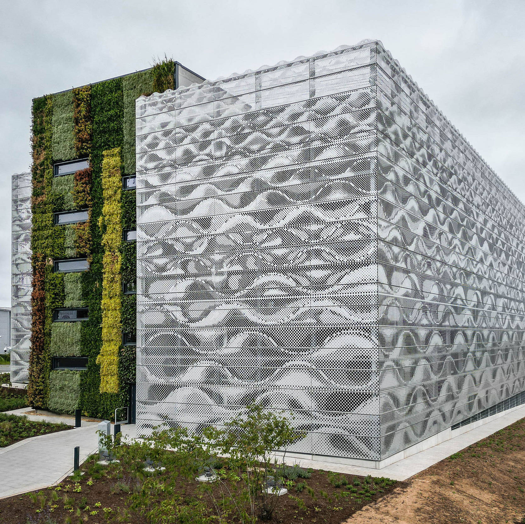Parkhausreferenz Sunderland in UK mit auffälliger Fassade aus grauen Wellen-Lamellen und durchgängiger Begrünung an der Treppenhaus-Außenfassade.