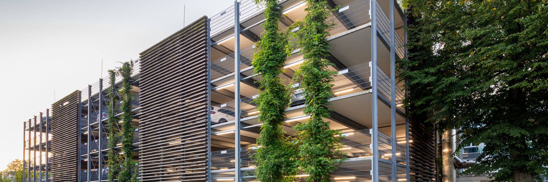 Multi-storey car park with a facade of wooden elements and greenery.