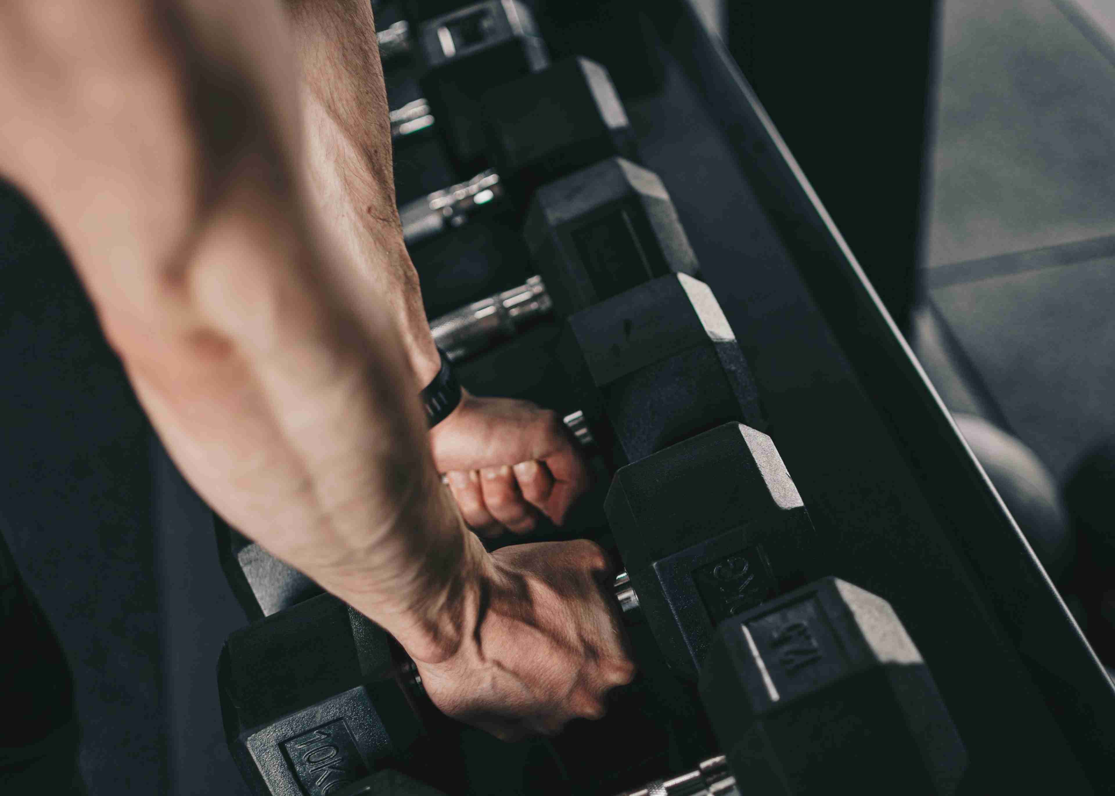 A man doing exercises with black dumbbells