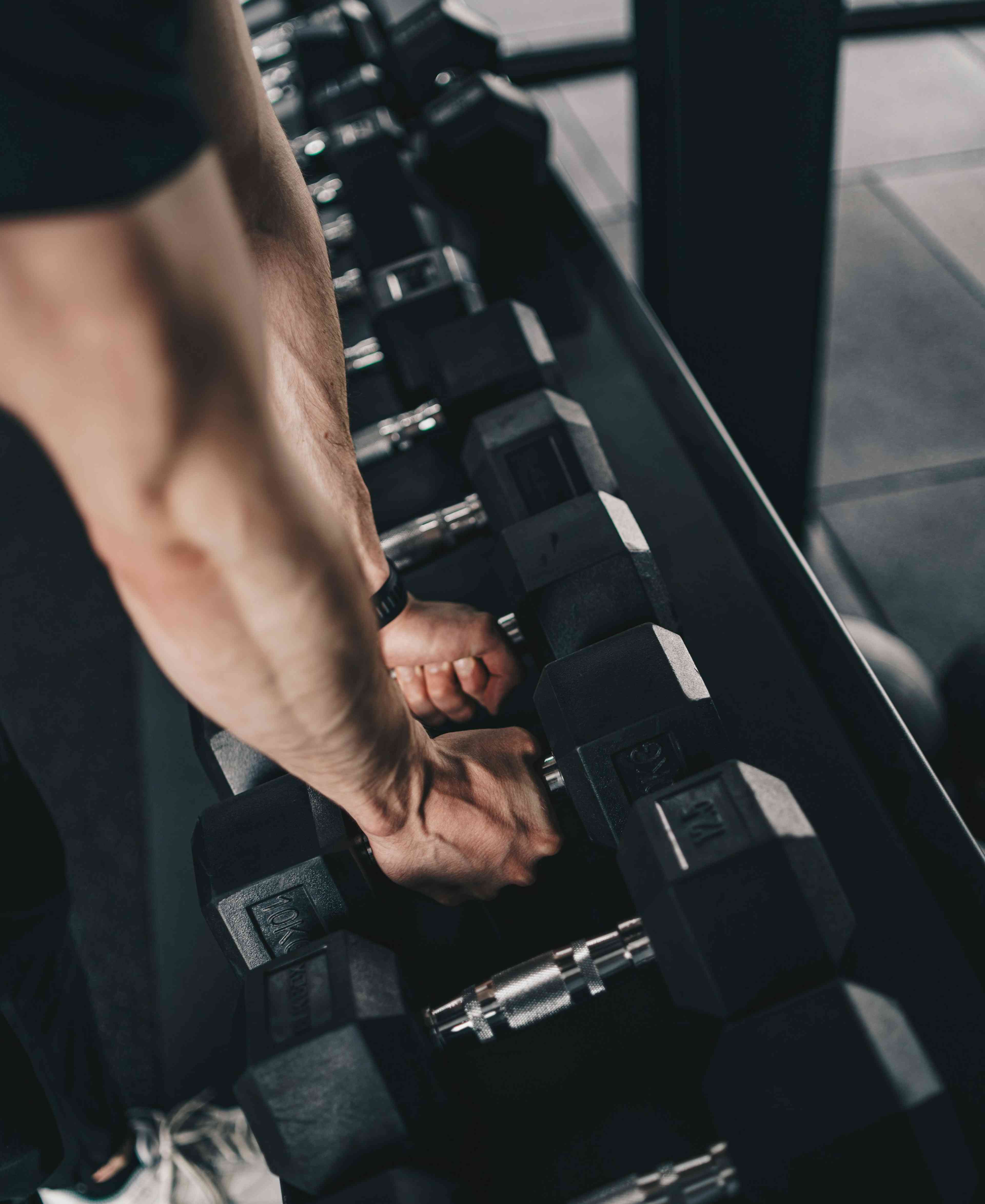 A man doing exercises with black dumbbells