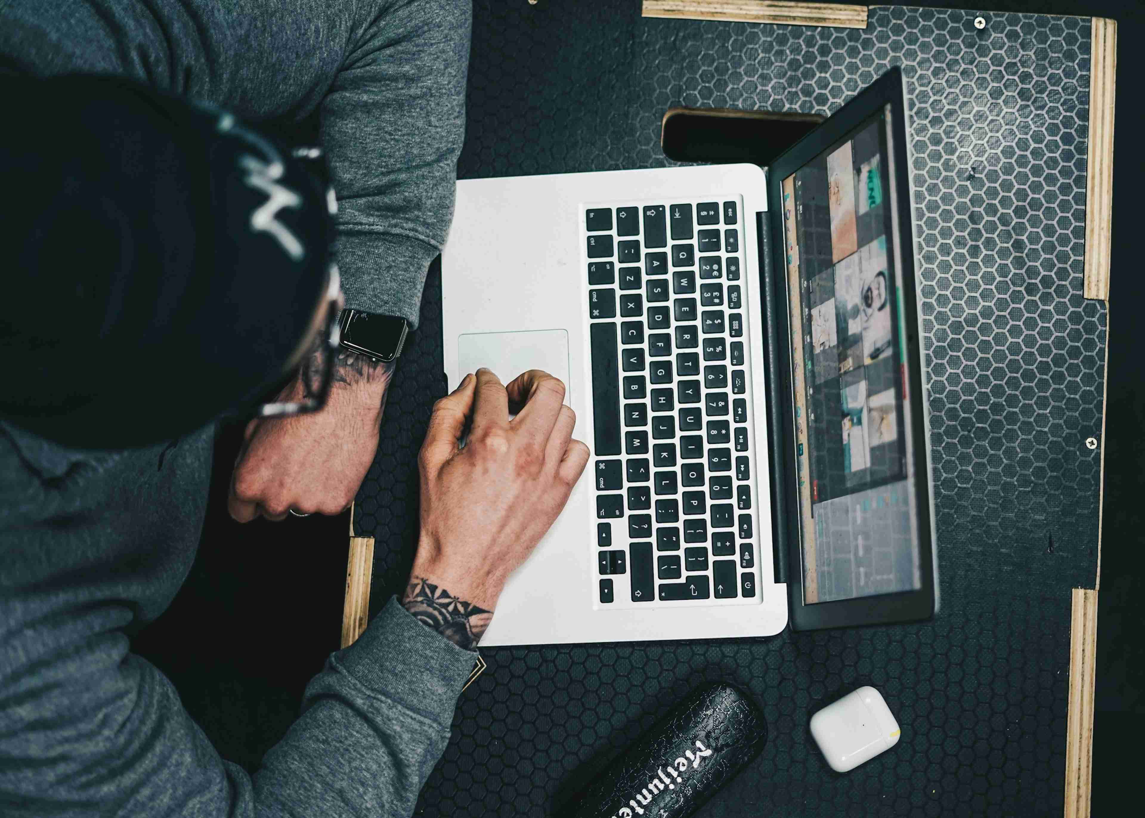 A personal trainer sitting at a desk using a laptop computer