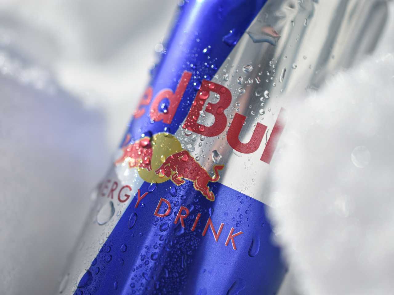 Cold can of Red Bull energy drink resting on crushed ice